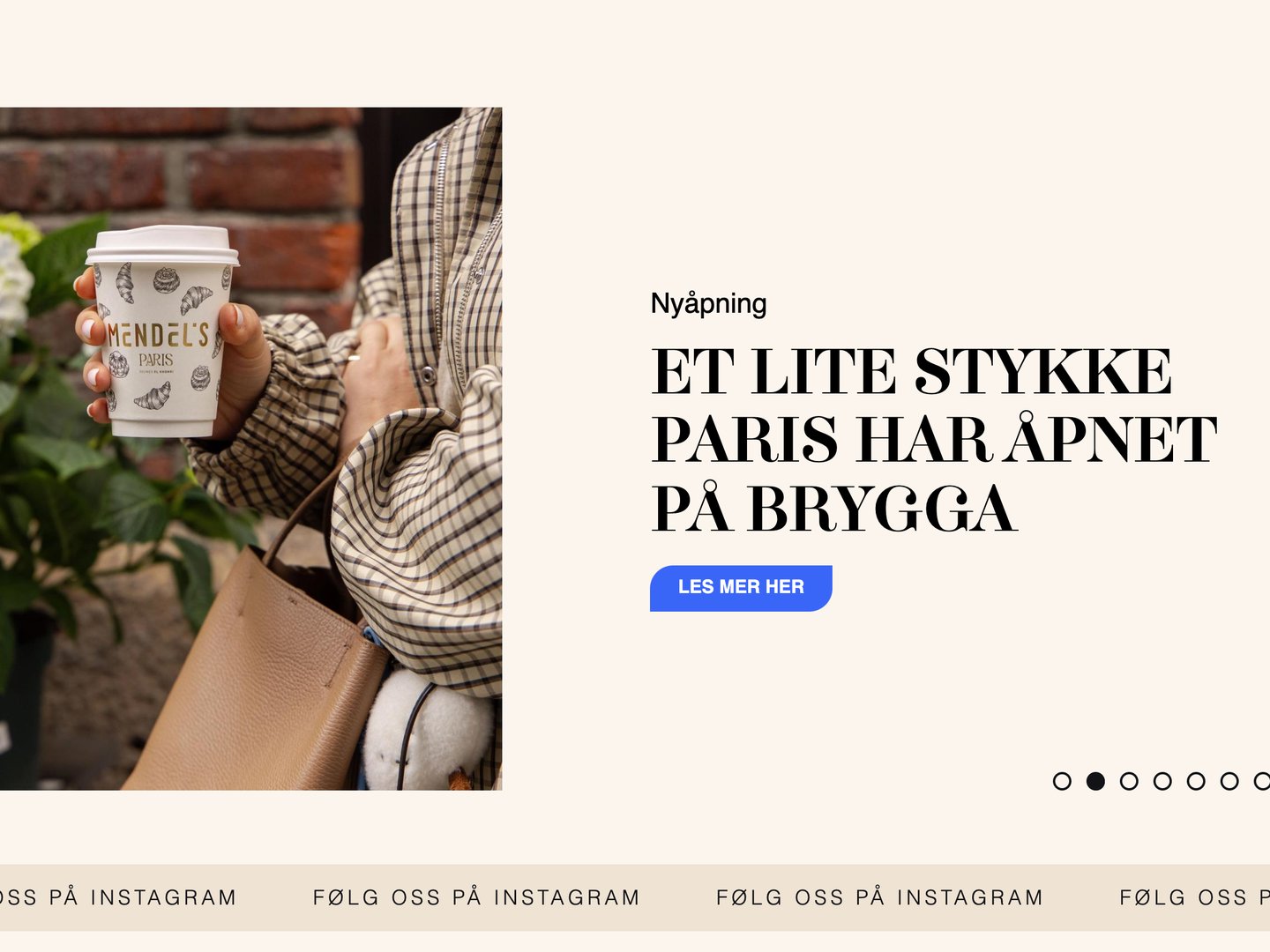 Utsnitt av forsiden til akerbrygge.no: en hånd som holder en kaffekopp fra Mendel's Paris, ved siden av overskriften «Et lite stykke Paris har åpnet på brygga» og knappen «Les mer her».